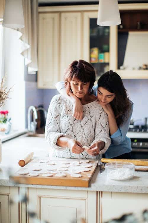 a mother and daughter baking in the kitchen.